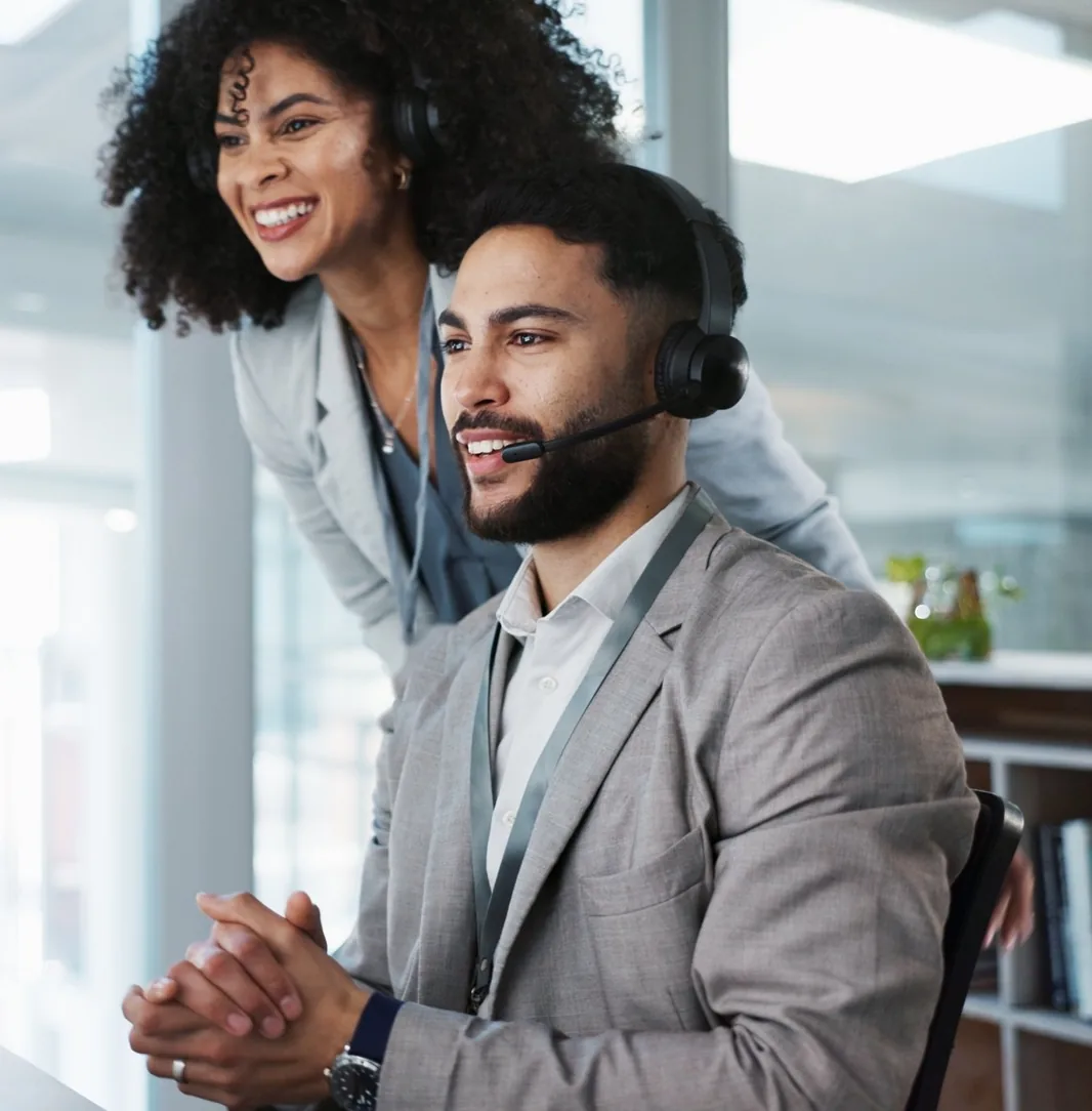 Sales manager coaching a sales rep at his desk