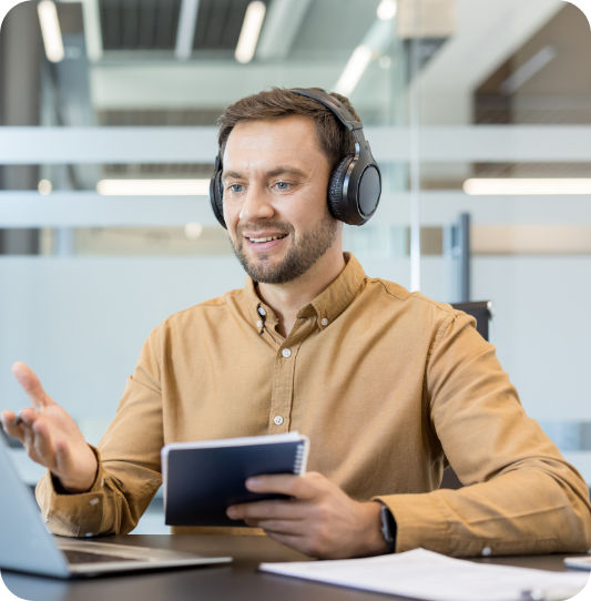 Inside sales rep on a sales call at his laptop, notebook in hand, during inside sales rep training